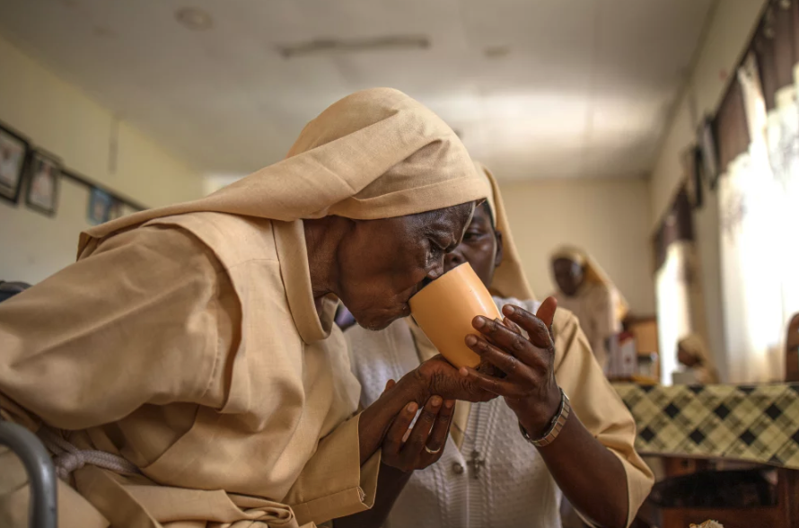 One Sister helping another Sister drink tea